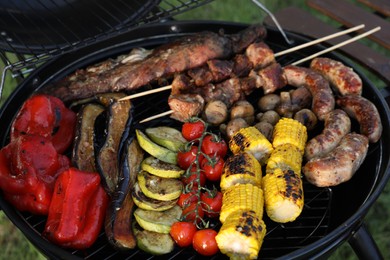 Tasty meat and vegetables on barbecue grill outdoors, closeup