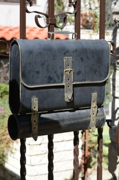 Black metal letter box on fence outdoors