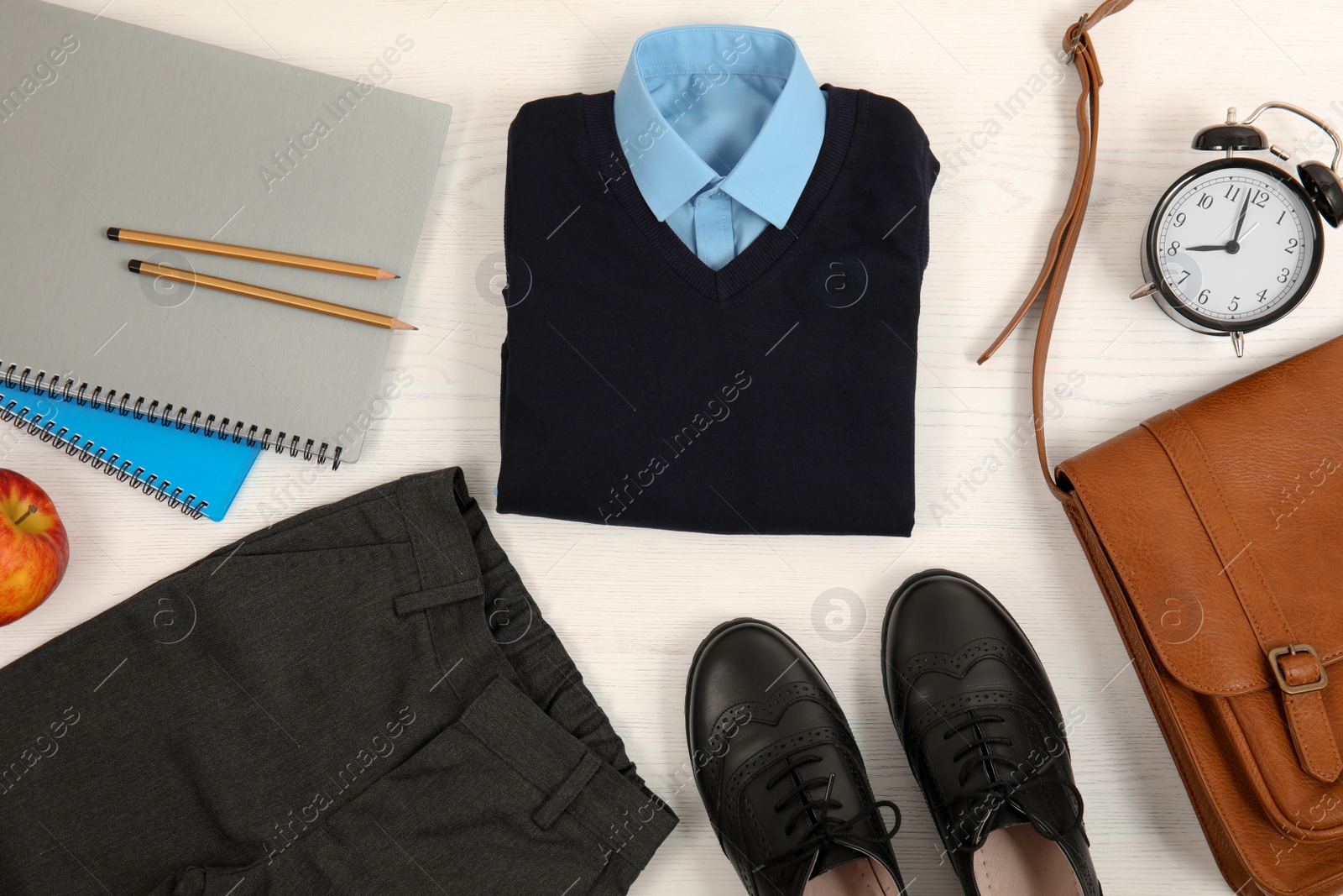 Photo of Composition with school uniform for boy on white wooden background, top view