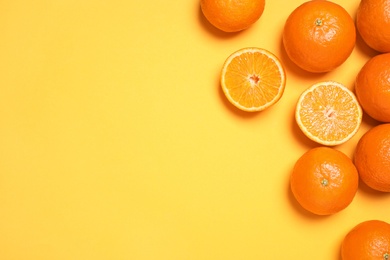 Photo of Fresh ripe tangerines on yellow background, flat lay. Space for text