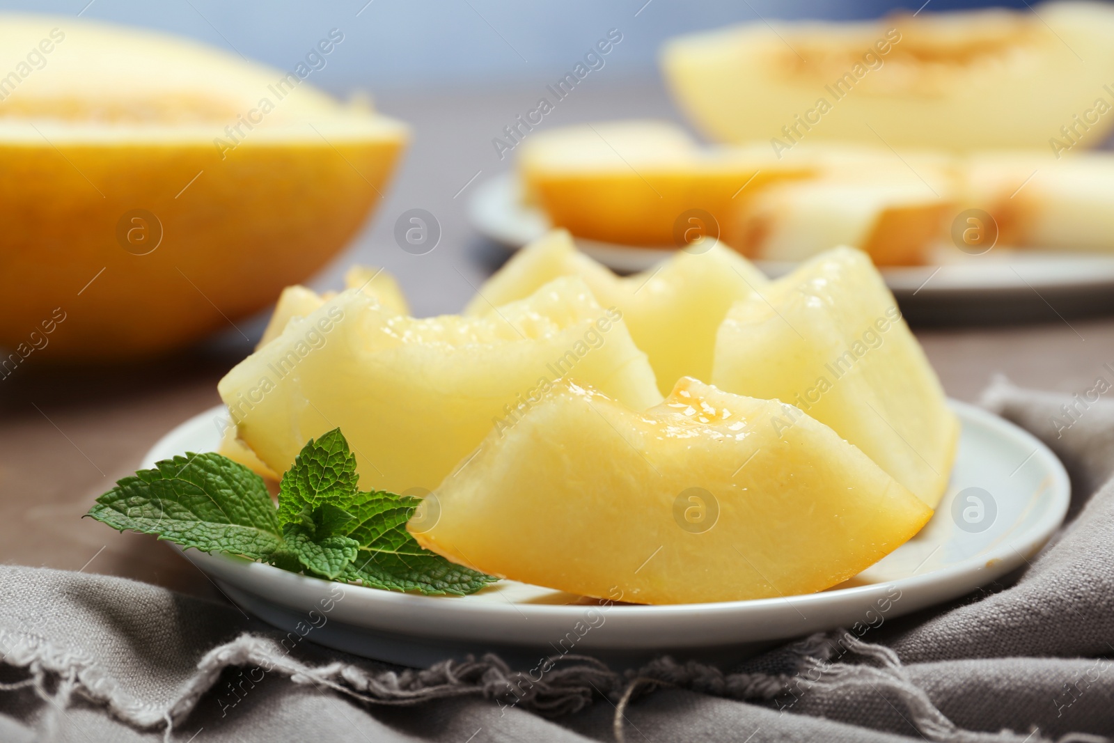 Photo of Plate with cut sweet melon on table
