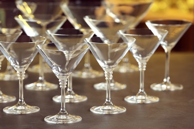 Photo of Empty martini glasses on table against blurred background