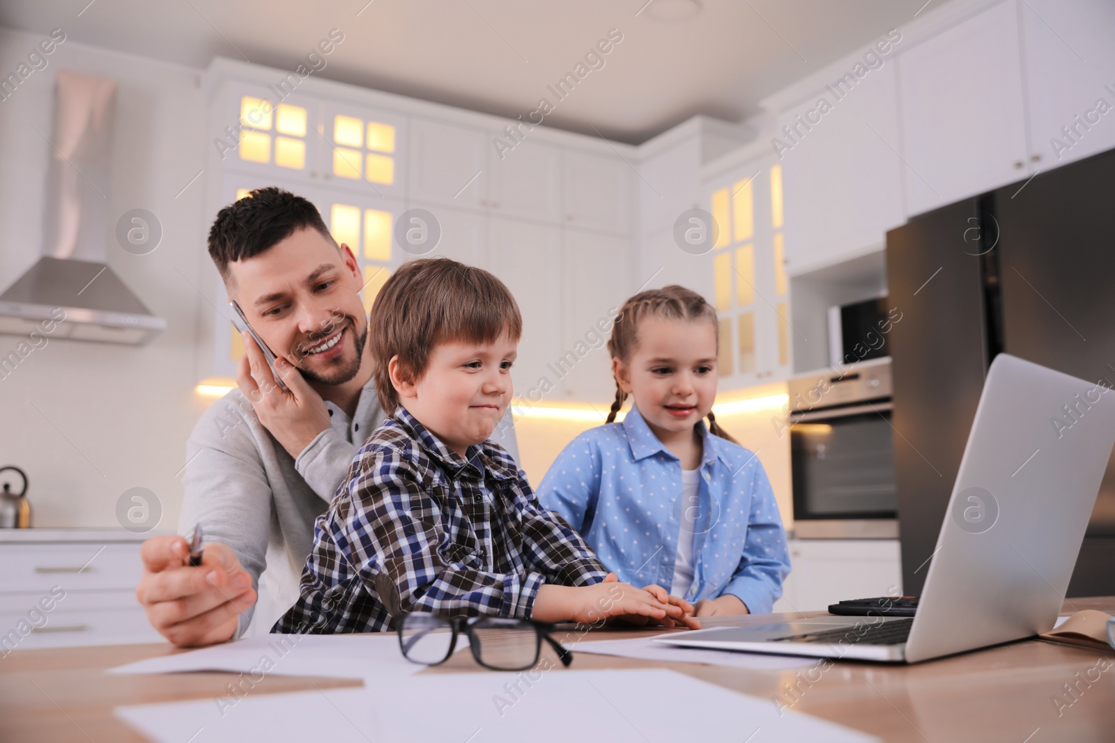 Photo of Happy man combining parenting and work at home