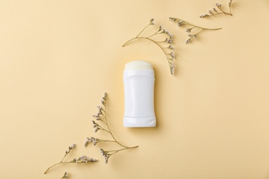 Photo of White deodorant and herbs on color background