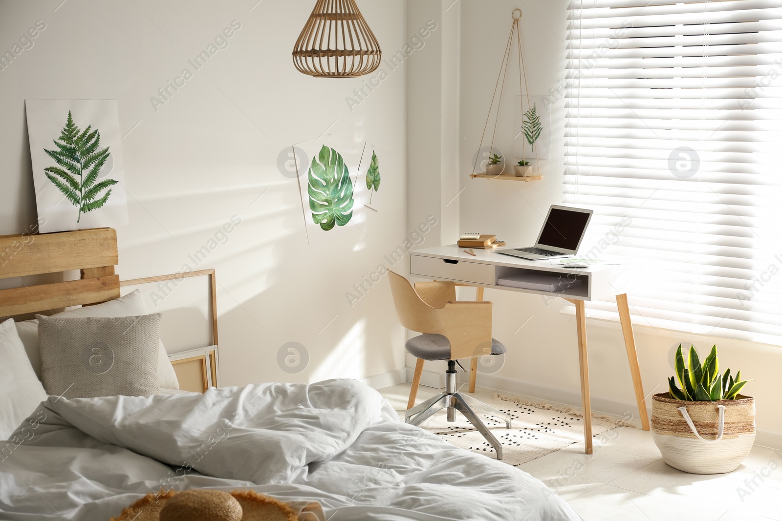 Photo of Stylish room interior with workplace and bed