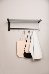 Bags and clothes on coat rack in hallway. Interior element