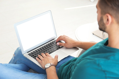 Image of Young man using modern computer at home, focus on hands. Space for design