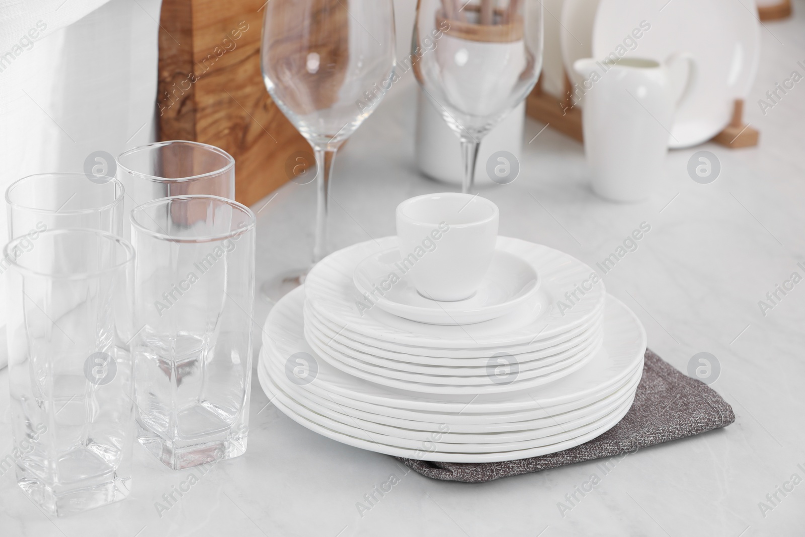 Photo of Clean dishes on light table in kitchen