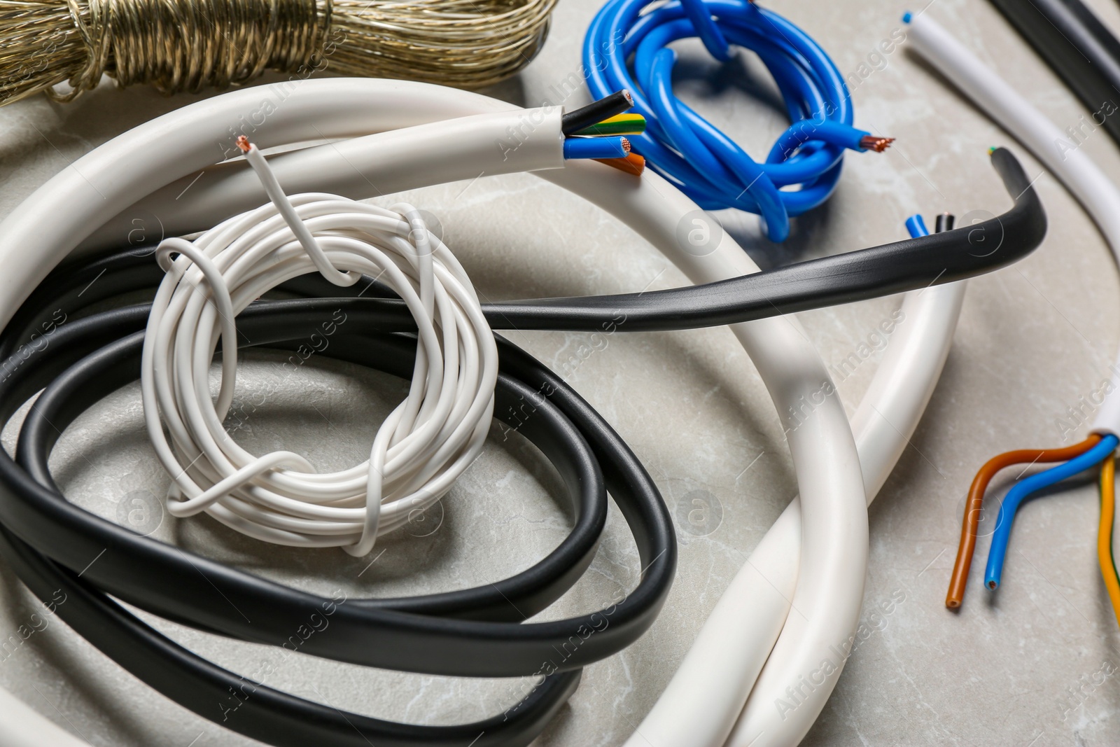Photo of Different electrical wires on light grey table, closeup