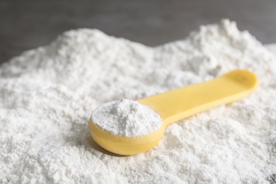 Scoop and pile of protein powder on table