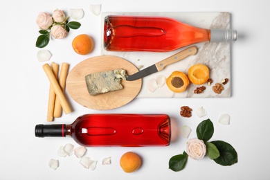 Composition with bottles of delicious rose wine on white background, top view