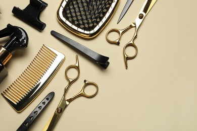 Photo of Different hairdresser tools on beige background, flat lay. Space for text