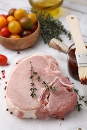 Photo of Raw meat, thyme, spices and marinade on white table, closeup