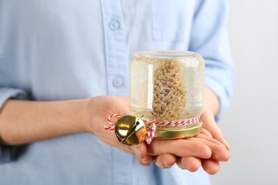 Woman holding handmade snow globe on white background, closeup