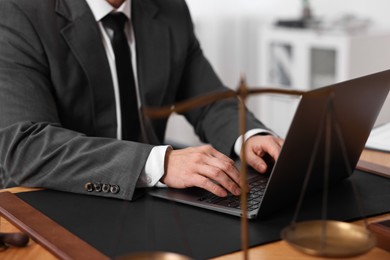 Photo of Notary working with laptop at wooden table in office, closeup