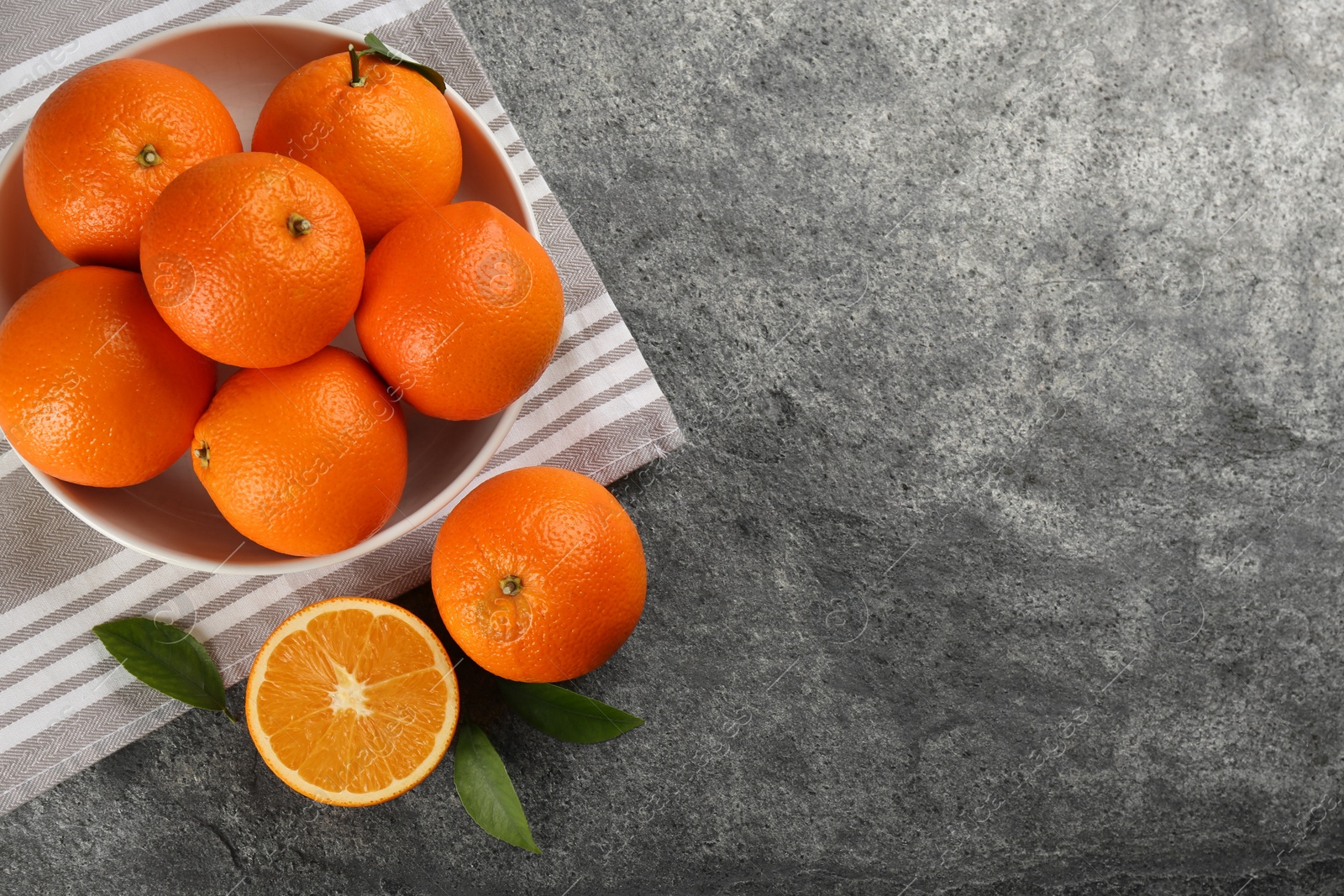 Photo of Delicious ripe oranges on grey table, flat lay. Space for text