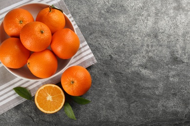 Photo of Delicious ripe oranges on grey table, flat lay. Space for text