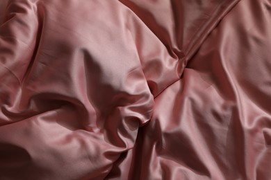 Photo of Closeup view of bed with beautiful pink silk linens