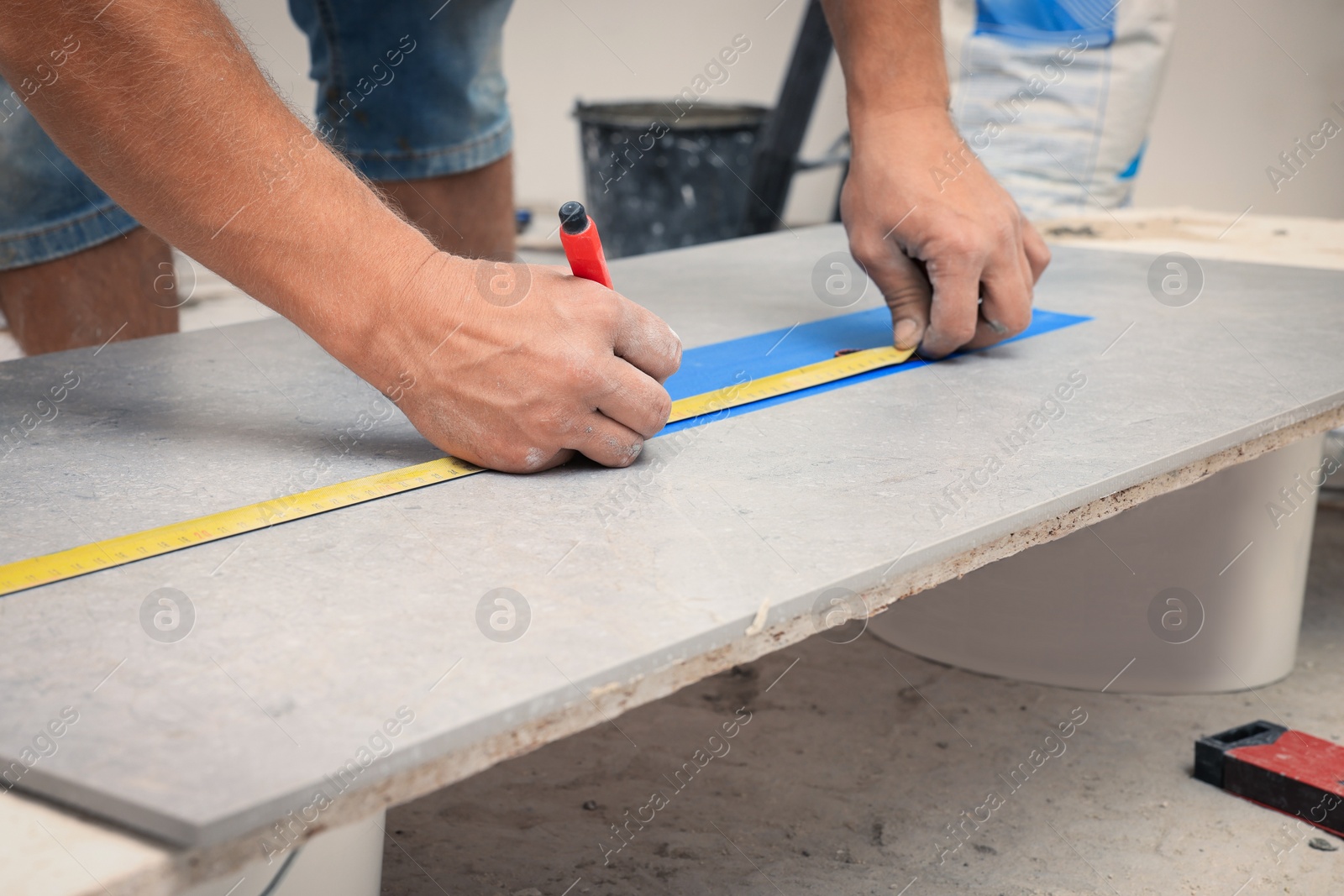 Photo of Worker making socket hole in tile indoors, closeup