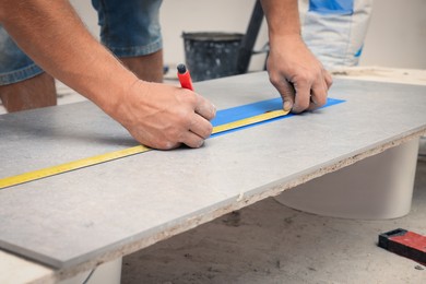 Worker making socket hole in tile indoors, closeup