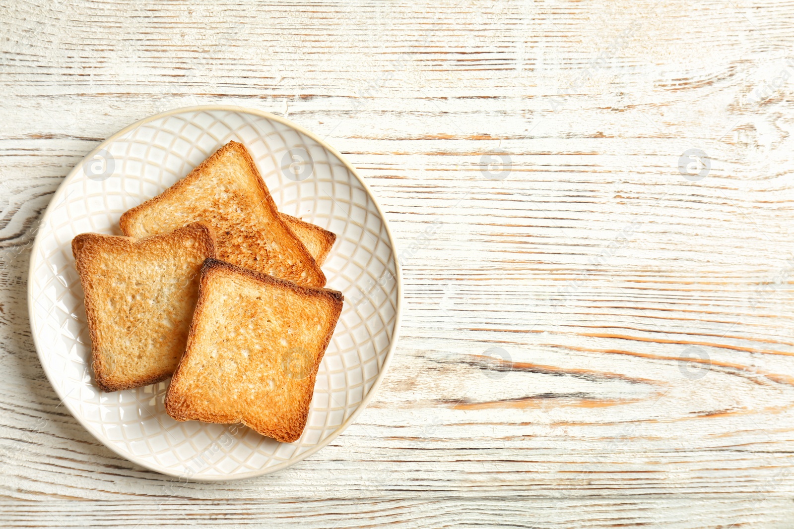 Photo of Plate with toasted bread on wooden background, top view