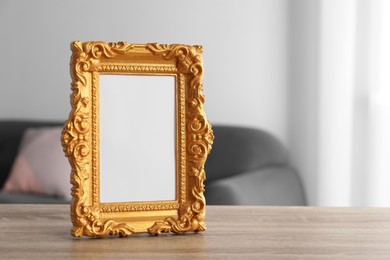 Empty photo frame on wooden table, space for text