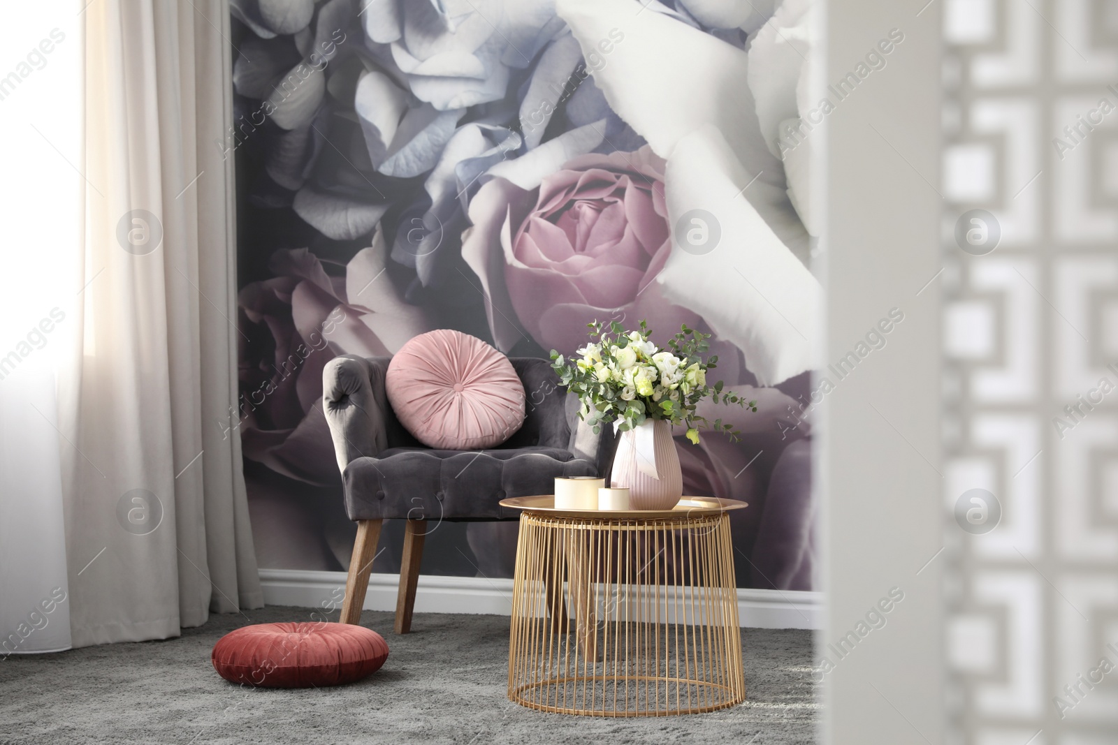 Photo of Comfortable armchair near wall with floral print. Stylish room interior