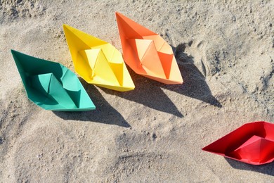 Photo of Many paper boats on sandy beach, above view