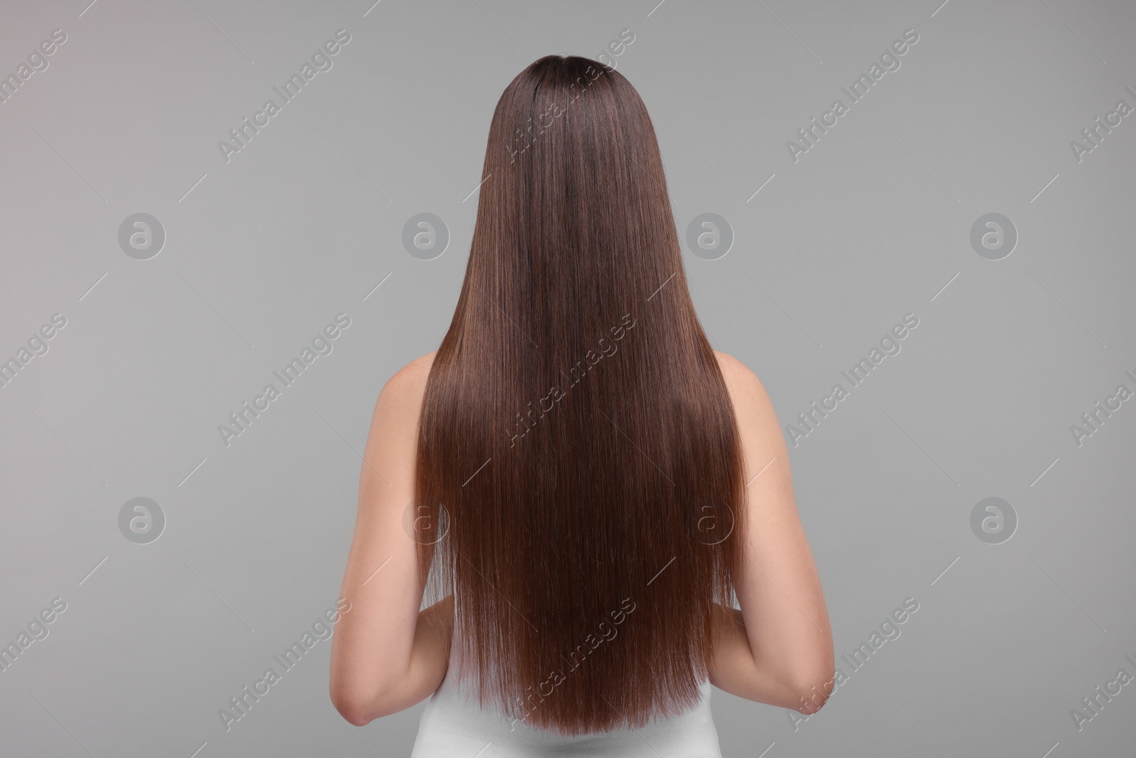 Photo of Woman with smooth healthy hair after treatment on light grey background, back view