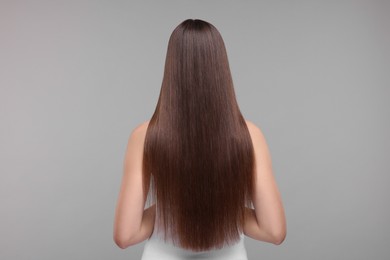 Photo of Woman with smooth healthy hair after treatment on light grey background, back view