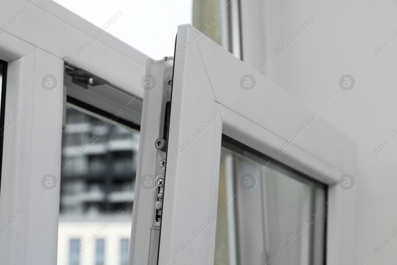 Photo of Open window with white plastic frame indoors, closeup