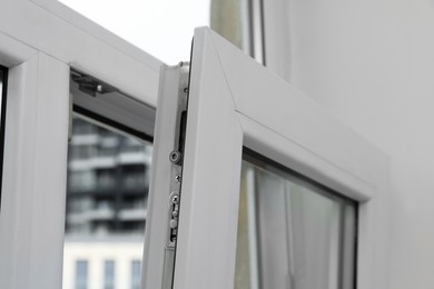 Photo of Open window with white plastic frame indoors, closeup