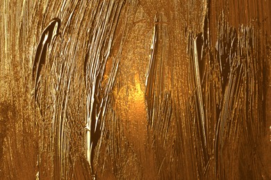 Image of Strokes of golden paint as background, closeup