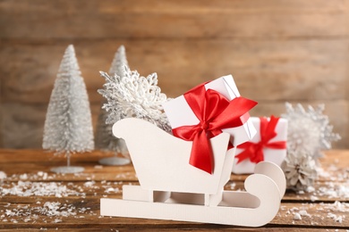 Beautiful Christmas composition with miniature sleigh on wooden table