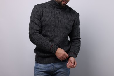 Man in stylish sweater on white background, closeup