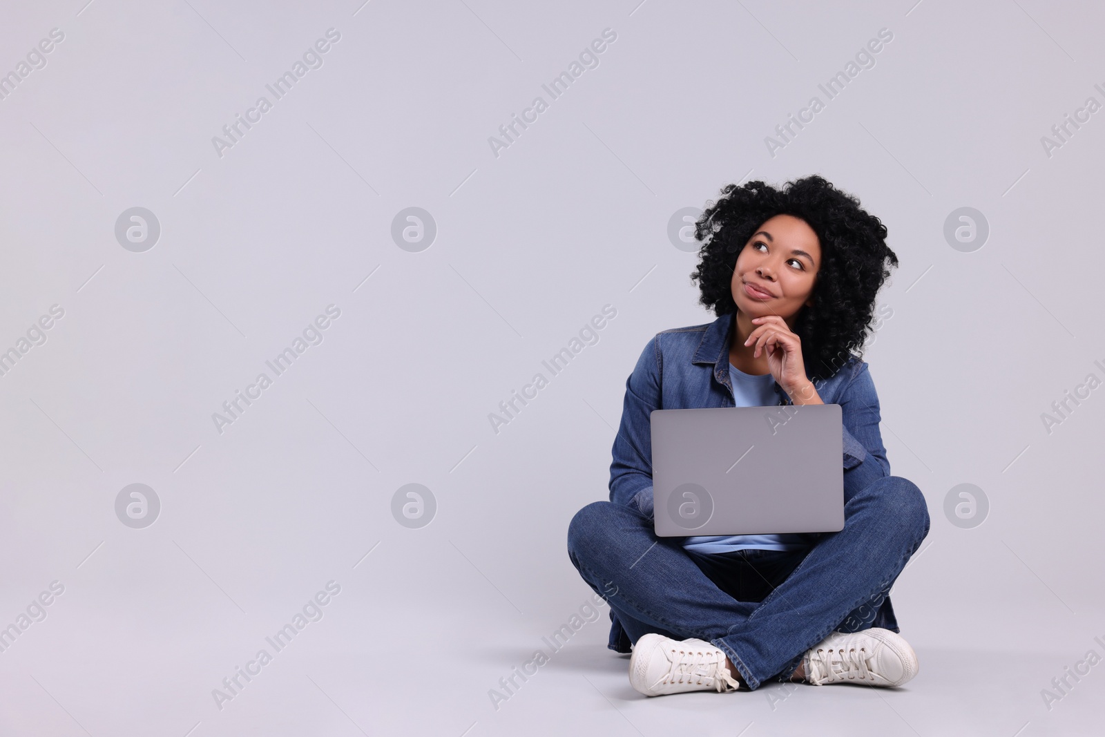 Photo of Beautiful young woman with laptop on light grey background. Space for text