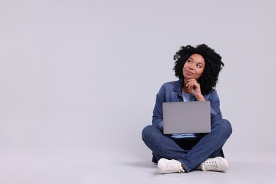 Photo of Beautiful young woman with laptop on light grey background. Space for text