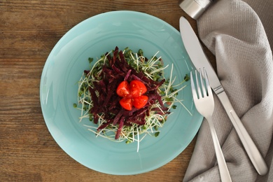 Photo of Delicious carrot salad served on wooden table, flat lay