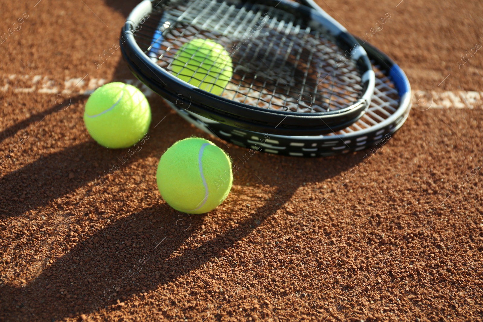 Photo of Tennis balls and rackets on clay court