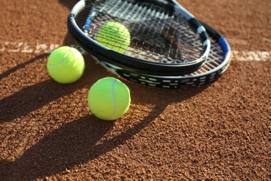 Tennis balls and rackets on clay court