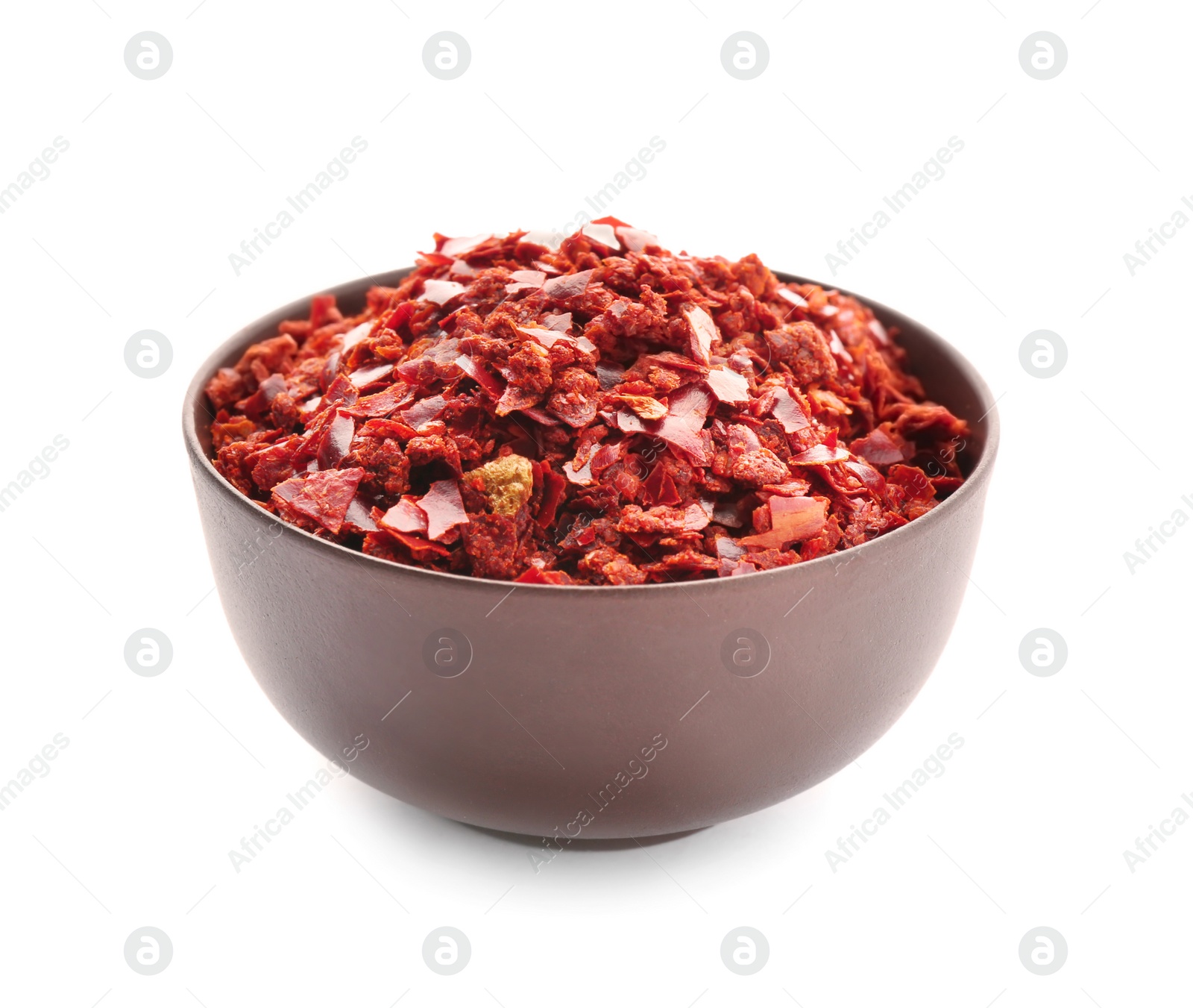 Photo of Bowl with chili pepper flakes on white background