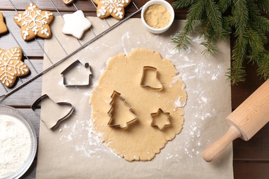 Making Christmas cookies. Flat lay composition with cutters and raw dough on wooden table