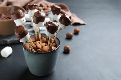 Delicious marshmallows covered with chocolate on black table. Space for text