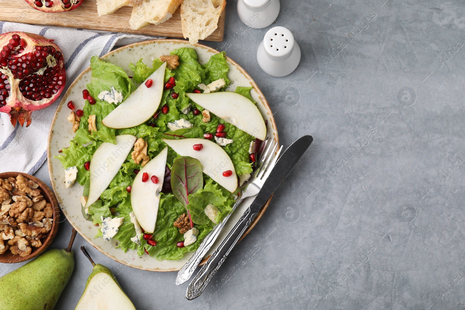 Photo of Delicious pear salad served on grey textured table, flat lay. Space for text