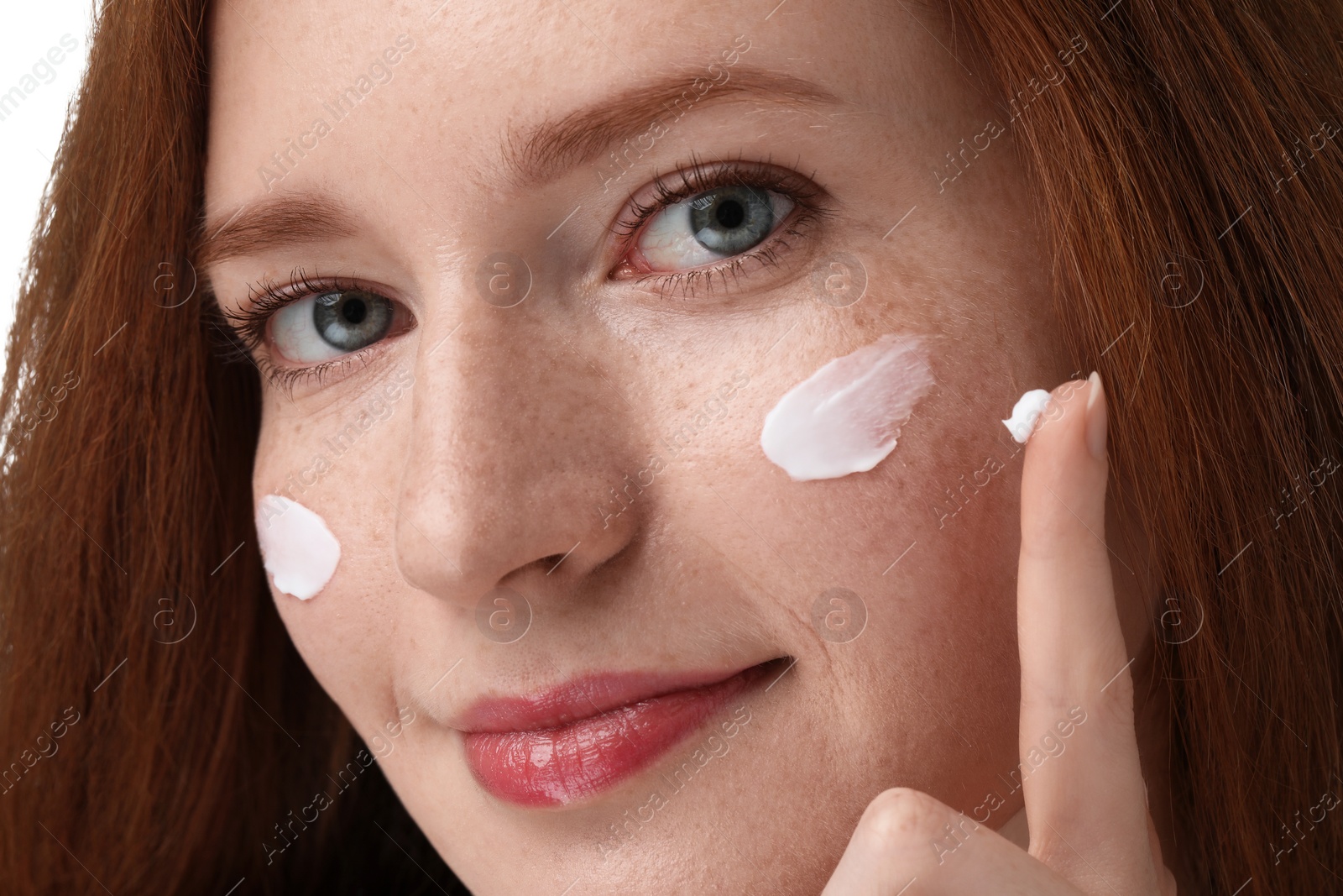 Photo of Beautiful woman with freckles and cream on her face, closeup