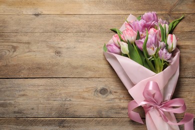 Beautiful bouquet of colorful tulip flowers on wooden table, top view. Space for text