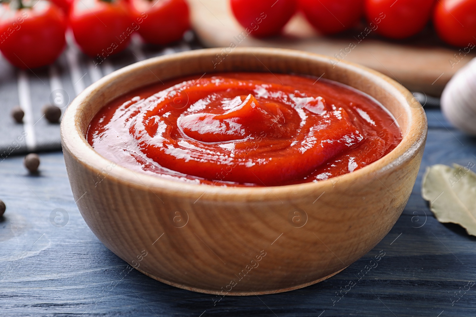 Photo of Delicious fresh tomato sauce on blue wooden table, closeup