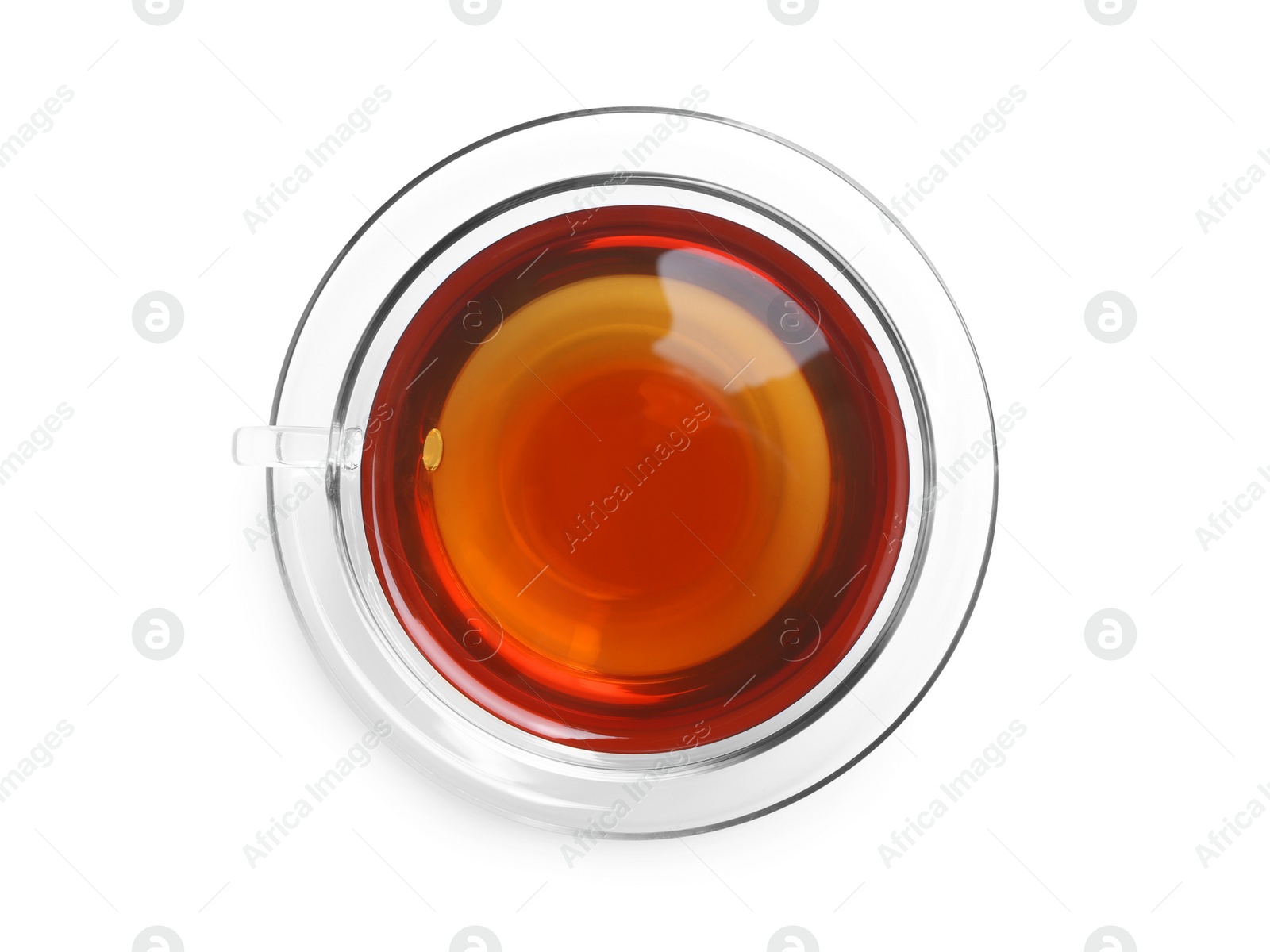 Photo of Glass cup of tea and saucer isolated on white, top view