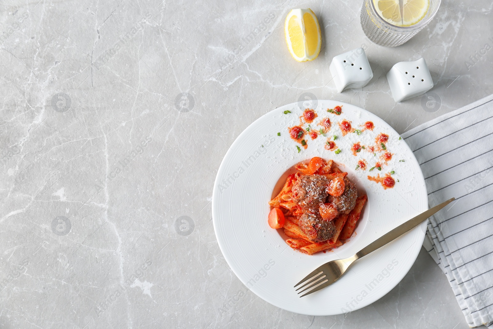 Photo of Delicious pasta with meatballs and tomato sauce on light background, flat lay