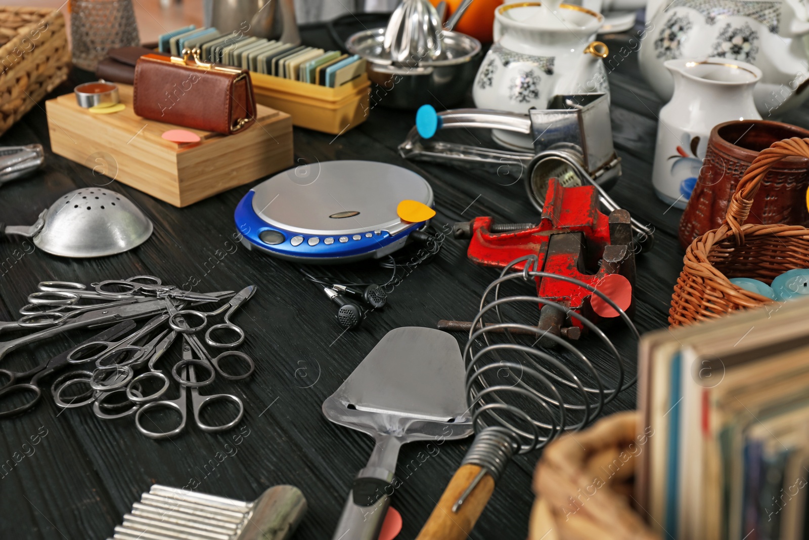 Photo of Many different stuff on black wooden table. Garage sale